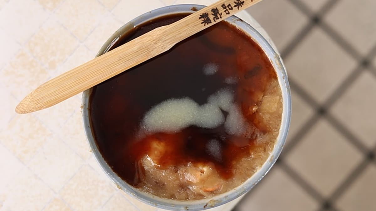 碗粿淋上店家特製的醬油、蒜末及少許辣椒醬，就是最完美的吃法。（圖片來源：熱血玩台南。跳躍新世界）