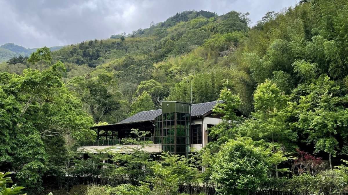 遠眺圓潭遊客中心，被樹林圍繞著風景很美。（圖片來源：雙子喵玩樂旅行PennyLife）