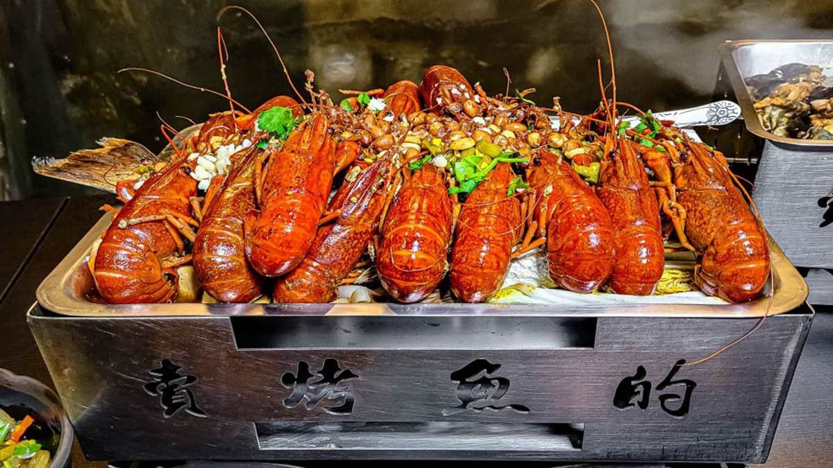 麻辣小龍蝦擺放在烤魚上頭，一送上桌就超吸睛。（圖片來源：饗食客棧。淘氣猴VS肥獅子的旅食天堂）