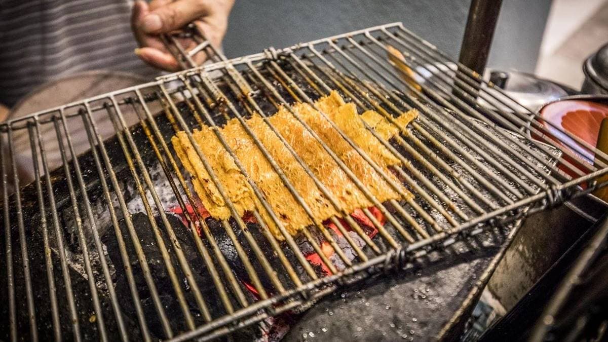 老闆會把魷魚片直接放至炭火上烤，邊烤還會邊刷特製醬料。（圖片來源：大手牽小手玩樂趣）