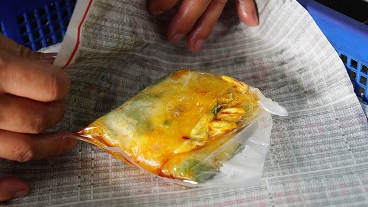 老闆會將九層塔蛋餅放入塑膠袋中，再用報紙包起來。（圖片來源：PEKO の Simple Life）