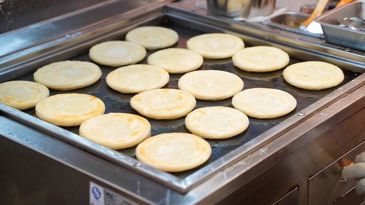 餅皮雙面煎至微微金黃後，會送進專門的烤爐裡烤出酥脆口感。（圖片來源：阿華田的美食日記）