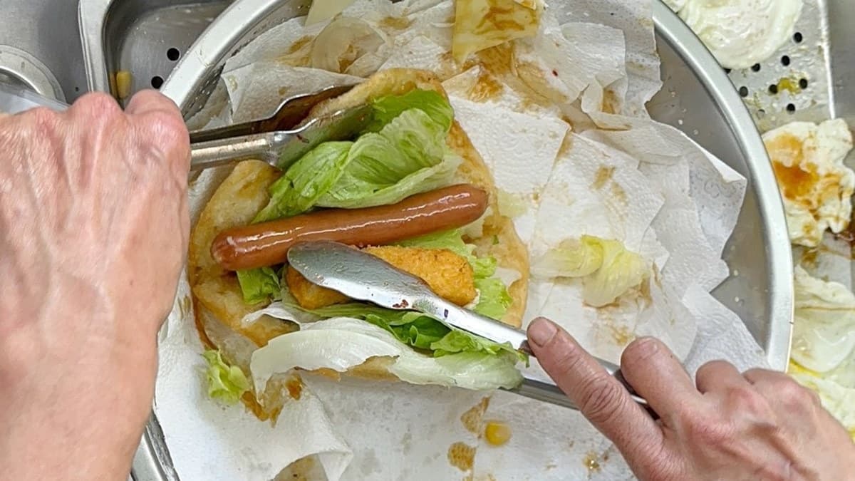 刷上特製醬料後，就開始塞入生菜、起司、德國香腸、鱈魚條。（圖片來源：阿華田的美食日記）
