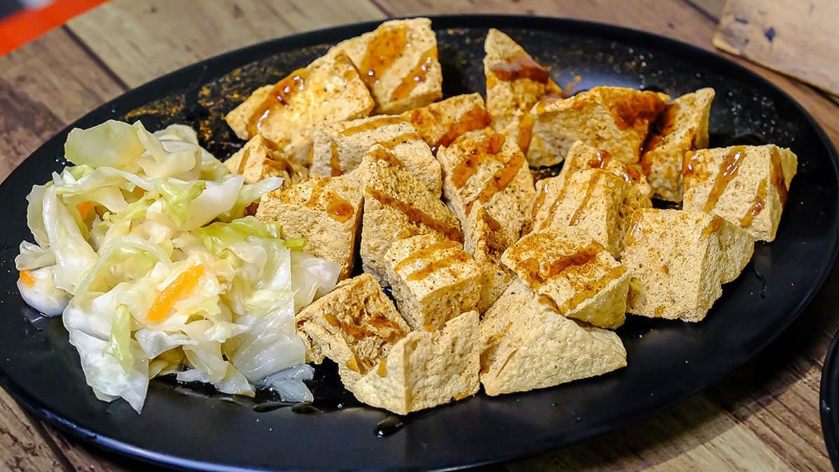 「三角酥臭豆腐」撒上中藥粉調味，吃起來口味更重，很適合當成下酒菜。（圖片來源：霸子。食樂拼圖）