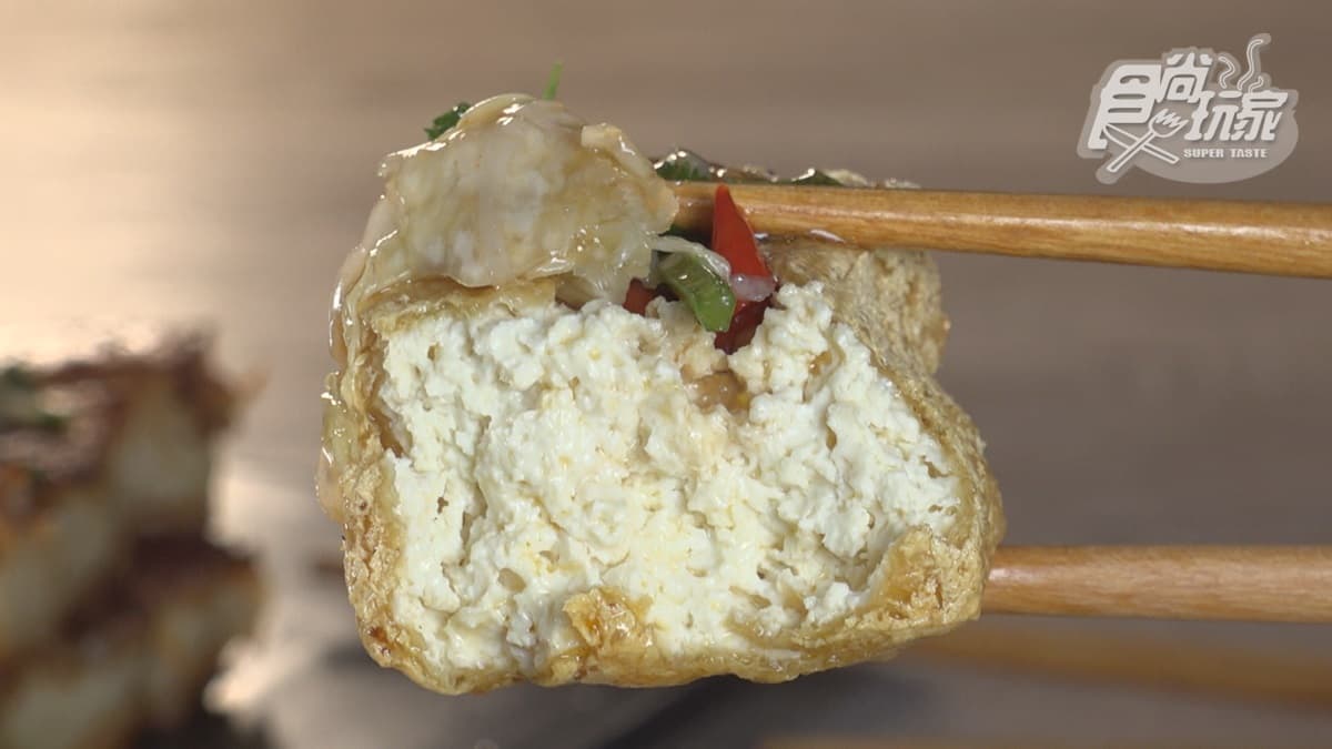 店裡的臭豆腐吃法是先塞入辣椒，再塞進泡菜一起吃。