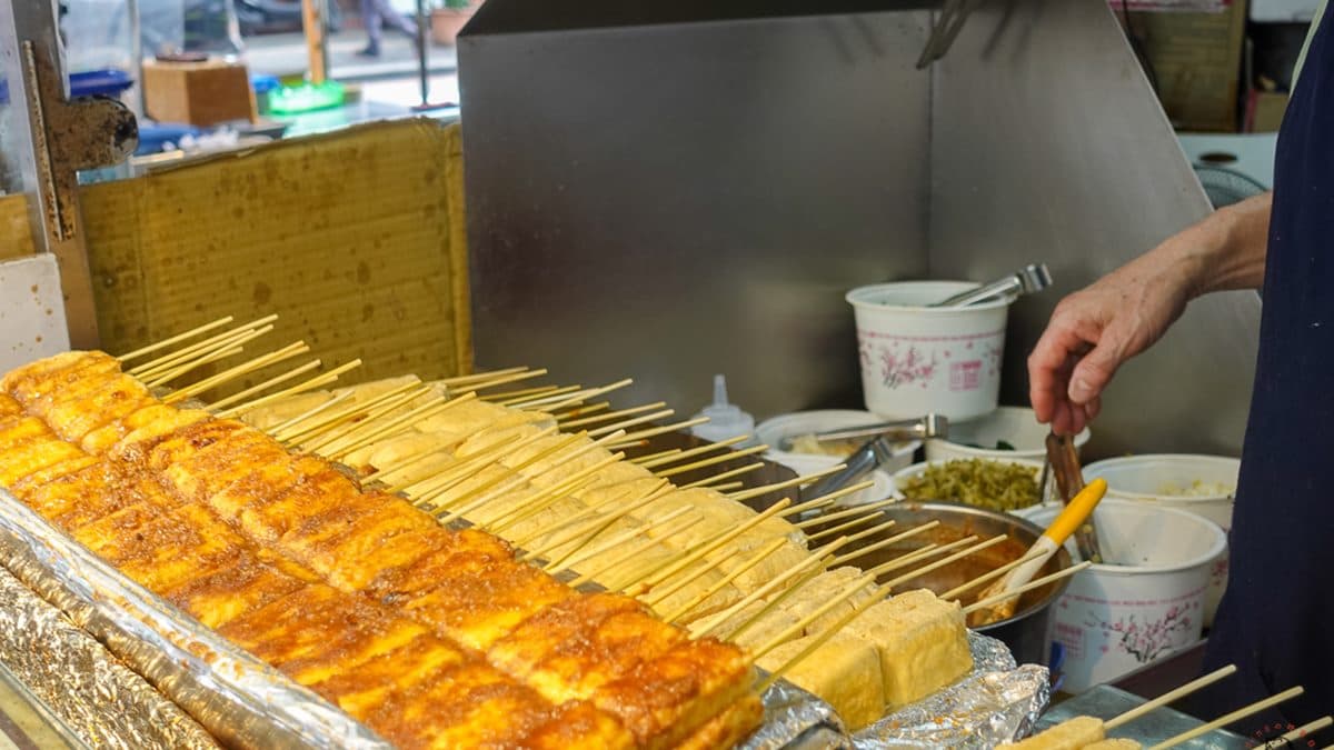 一串串臭豆腐在架子上排列整齊，看起來好療癒。（圖片來源：丁Dingの吃貨日常）