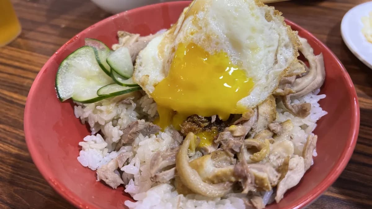 鴨肉飯搭上半熟的荷包蛋，美味更上一層樓。（圖片來源：勞鼠探世界）