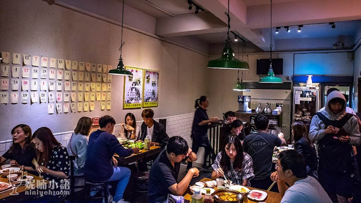 店內裝潢以白牆配上白色磁磚為主，還有鐵架吊燈和一張張貼皮的木桌，充滿著台味。（圖片來源：妮喃小語）