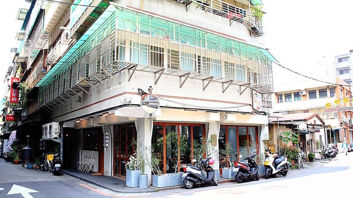 店面水泥灰色外觀，搭配木頭老門顯得很復古。（圖片來源：upssmile向上的微笑萍子 旅食設影）