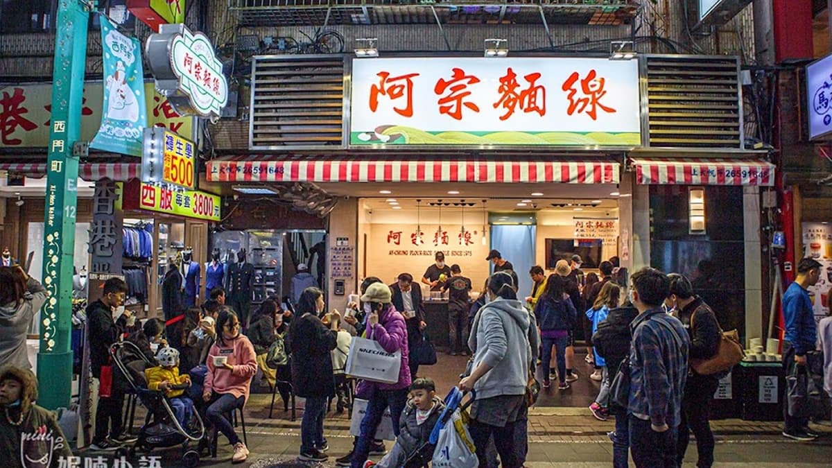 店門口或站或坐，人手一碗。（圖片來源：妮喃小語）