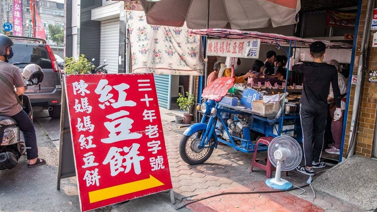 門面就是一般住家，騎樓有１台藍色的三輪車，紅豆餅就是在這販售、製作。（圖片來源：大手牽小手。玩樂趣）