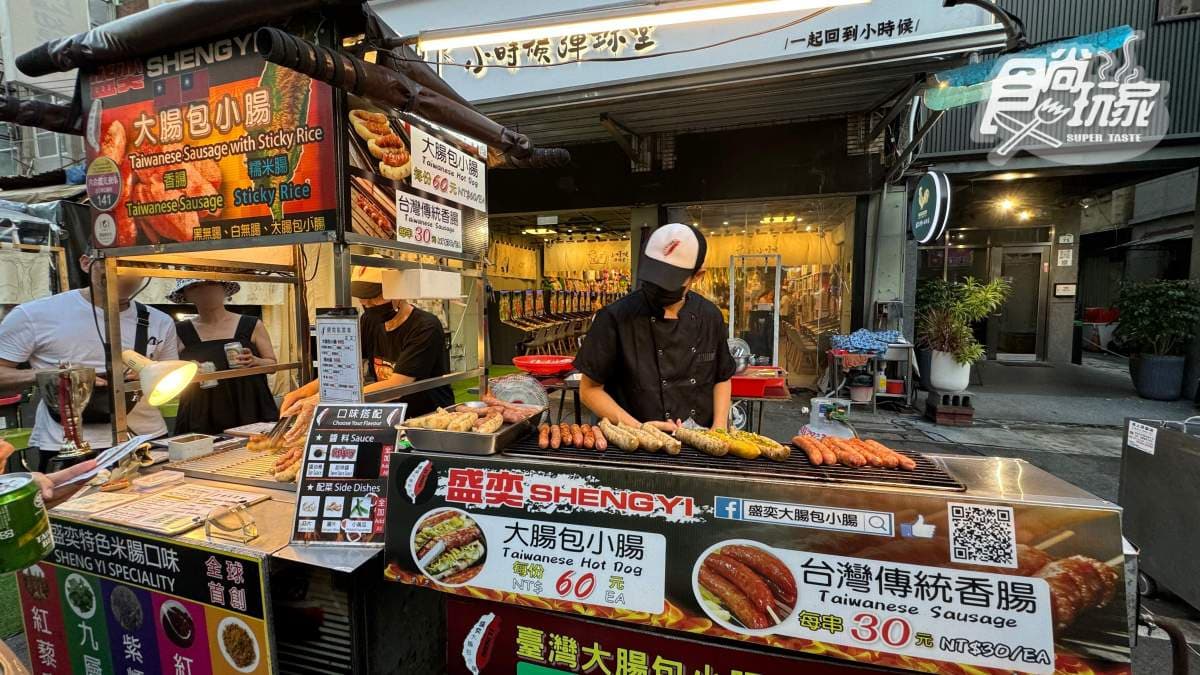 攤位上的香腸烤得滋滋作響，吸引不少外國遊客排隊購買。