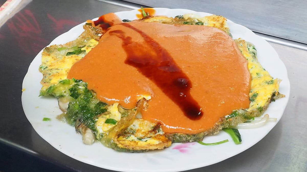 蚵仔煎有淋上厚厚的紅色醬料及醬油。（圖片來源：霸子。食樂拼圖）