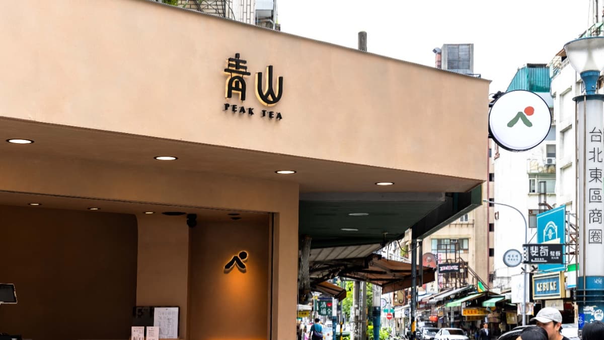 店內以手刷感淺杏仁色，營造出樸質感，櫃台左側還設有附小邊桌的座位區。（圖片來源：青山PeakTea）