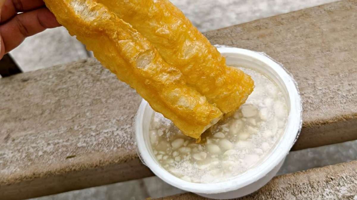 油條浸泡在花生湯，大口吃下花生湯在嘴裡爆漿。（圖片來源：DARREN蘋果樹旅遊玩樂誌）