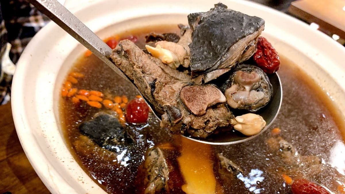 「陳年菜圃烏骨雞湯」搭配蒜頭、蛤蠣、枸杞等一起提味，湯頭很鮮。（圖片來源：猴屁的異想世界）