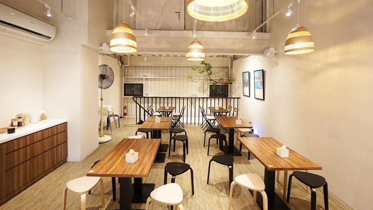 內用空間有挑高設計，搭配木質色調的桌椅與地板。（圖片來源：老錢的老巢）