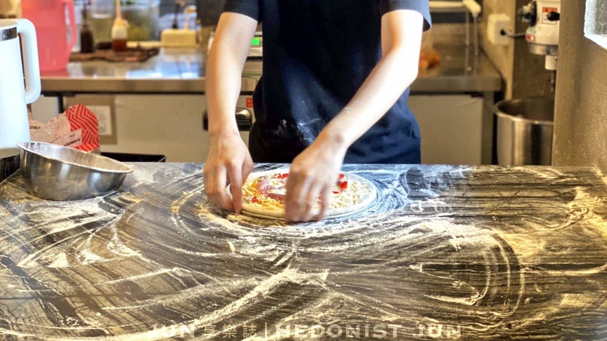 每一張披薩都是當場揉捏麵糰、撒上食材配料，進窯爐現烤而成。。（圖片來源：JUN 享樂誌）