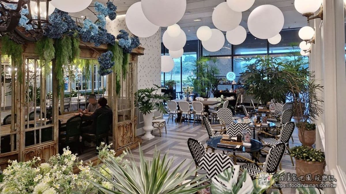 店內以白色為主色調，搭配綠色植物、復古街燈及黑白紋座椅，營造法式優雅氛圍。（圖片來源：台南美食地圖）