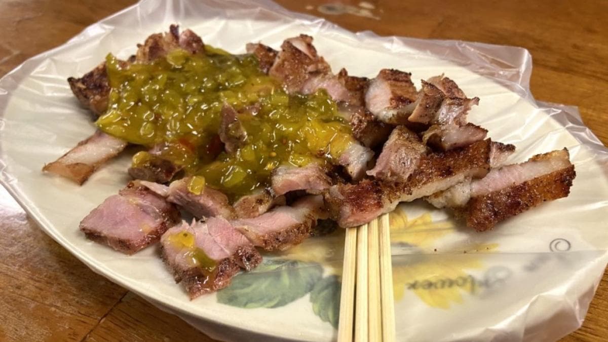 「碳烤醃豬肉」撒上偏甜的酸黃瓜，意外讓鹹豬肉的味道層次更豐富。（圖片來源：勞鼠探世界）