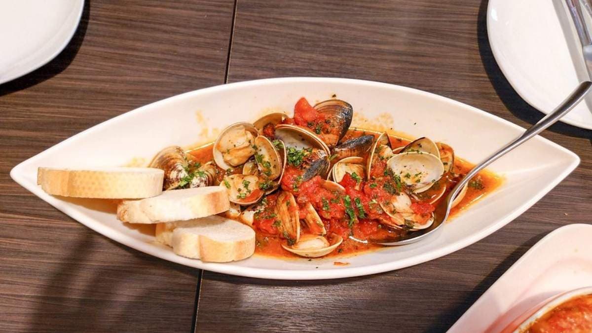 「白酒蛤蠣」以番茄醬汁和白酒拌炒，蛤蠣很大顆又飽滿多汁。（圖片來源：Jeremy以食為天）