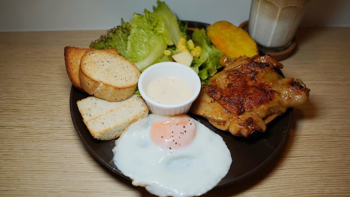 「咕雞咕雞」早午餐有黎麥麵包，手掌大的迷迭香雞腿排。（圖片來源：東蛙池塘）