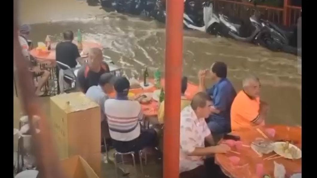 信徒在暴雨中吃流水席。（圖／民眾提供） 正港流水席！嘉義普渡宴遇暴雨　信徒泡水吃、辣妹嗨熱唱