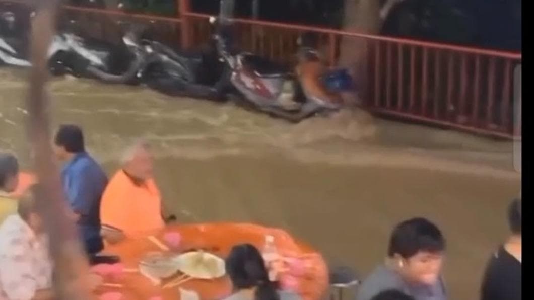 雨勢正激烈沖刷著一旁的機車。（圖／民眾提供） 正港流水席！嘉義普渡宴遇暴雨　信徒泡水吃、辣妹嗨熱唱